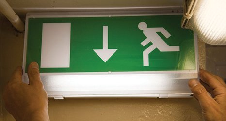 Green and white fire exit sign with hands