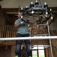 man installing and large black chandelier